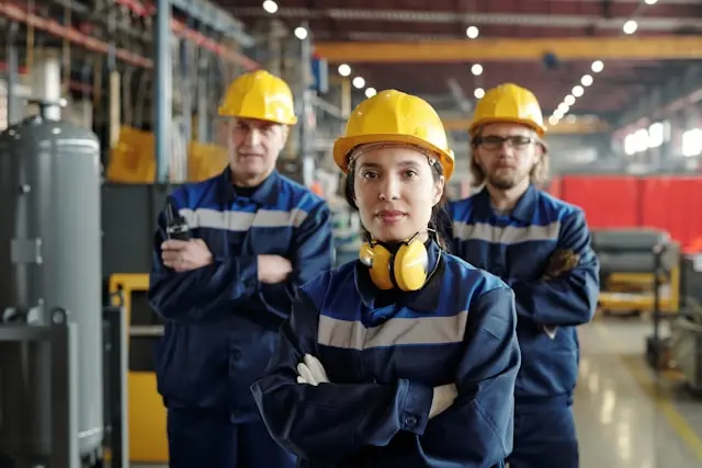 tres trabajadores con brazos cruzados